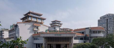 A hotel with traditional architectural elements, including tiered roofs and a central entrance.