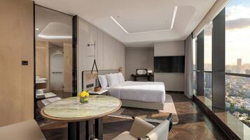 A modern hotel room with a large bed, a round table with a vase, a city view, and a balcony.