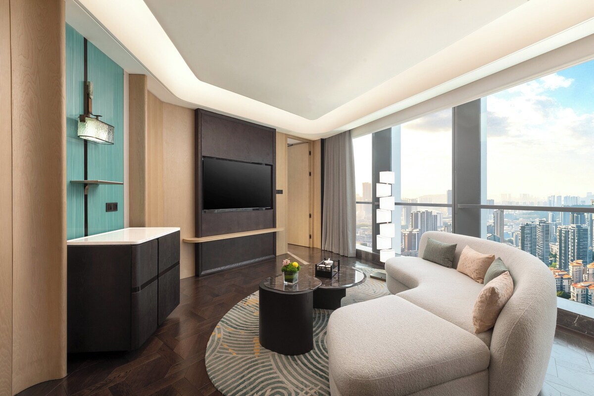 A modern living room with a large flat-screen TV, a sofa, and a coffee table.
