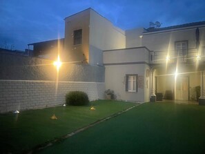 Un bâtiment doté d’un toit plat, d’un mur en briques et d’une pelouse bien entretenue.