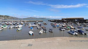 Un puerto deportivo con barcos amarrados, un edificio de techo plano y un cielo despejado.