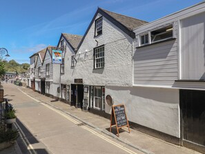 A street with traditional buildings, a sign for 'The Royal Standard,' and a chalkboard sign advertising food and drinks. - Avocet (Lyme Regis)
