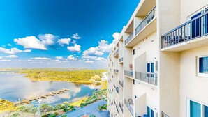 A high-rise hotel with balconies overlooking a lake and greenery. - Pinnacle Port A-929 (Panama City Beach)