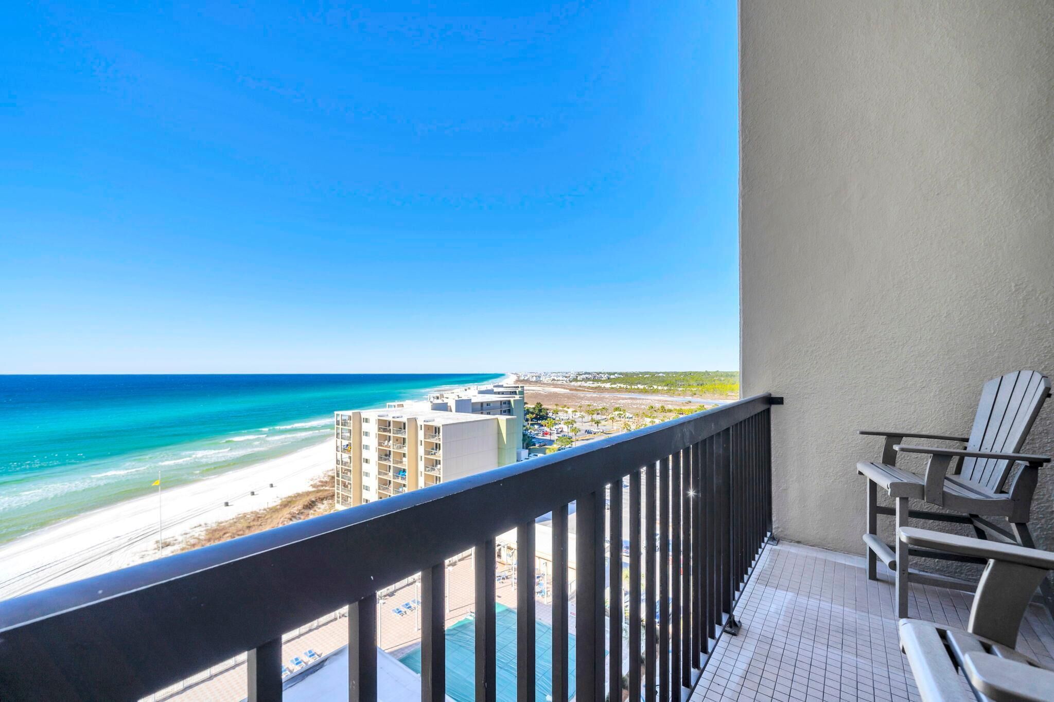 A balcony with a view of a beach and ocean.