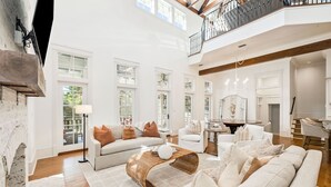 A spacious living room with a high ceiling, large windows, and a balcony. - Close to Communal Pool with LSV (Santa Rosa Beach)
