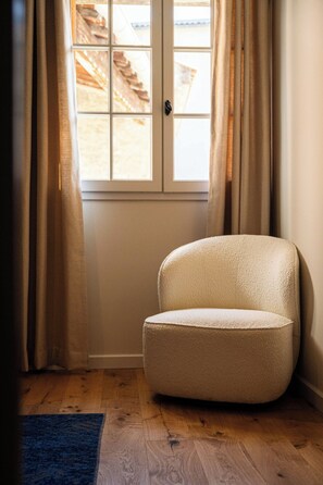 A corner room with a window, a chair, and wooden flooring. - Apartment "Saint-Rémy" (Saint-Rémy-de-Provence)