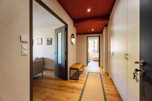 A hallway with wooden flooring, a bench, a sofa, and a wardrobe. - Apartment "Saint-Rémy" (Saint-Rémy-de-Provence)