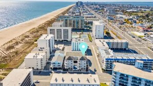 An aerial view of a coastal city with a beach, modern buildings, and a prominent location marker. - Gorgeous Beach Retreat Semi-Private Pool Views Bikes Grill (Ocean City)