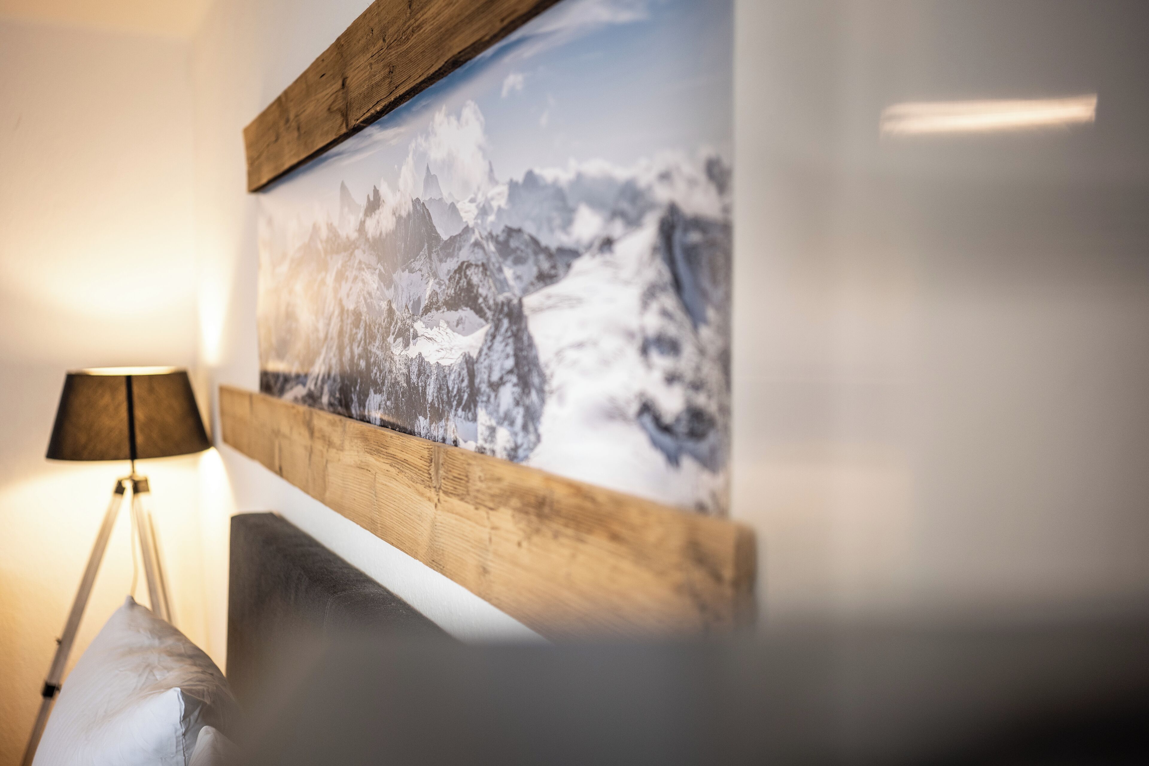 A framed photograph of a snowy mountain landscape on a wall.