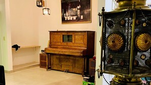 Un soggiorno con un pianoforte, un tavolino da caffè in vetro e una lampada decorativa in metallo.