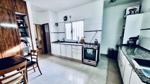 Una cucina con mobili bianchi, un fornello a gas e un lavello.
