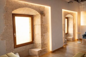 Um interior moderno com arcos de pedra, uma porta de madeira e um pequeno espaço de estar.