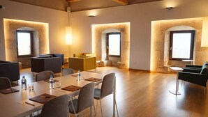 A modern conference room with a long table, chairs, and a small seating area with sofas. - Hotel Santuari Balaguer (Balaguer)