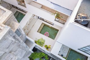 A multi-level building with a central courtyard, outdoor seating, and a water feature. - Private Pool Villa w/ Ricefield Views • 8 Min to Seseh Beach (Badung Regency)