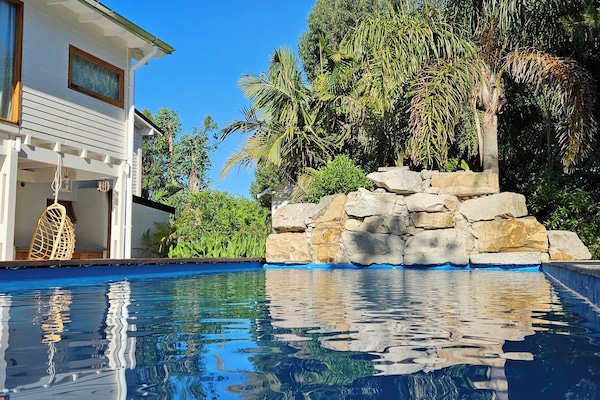 Alberca al aire libre, sombrillas en la alberca y camastros