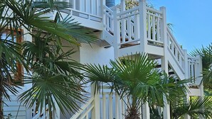 A two-story building with a white exterior, a balcony, and a staircase leading to the upper floor. - Complejo Pelicano Chapadmalal (Colonia Chapadmalal)