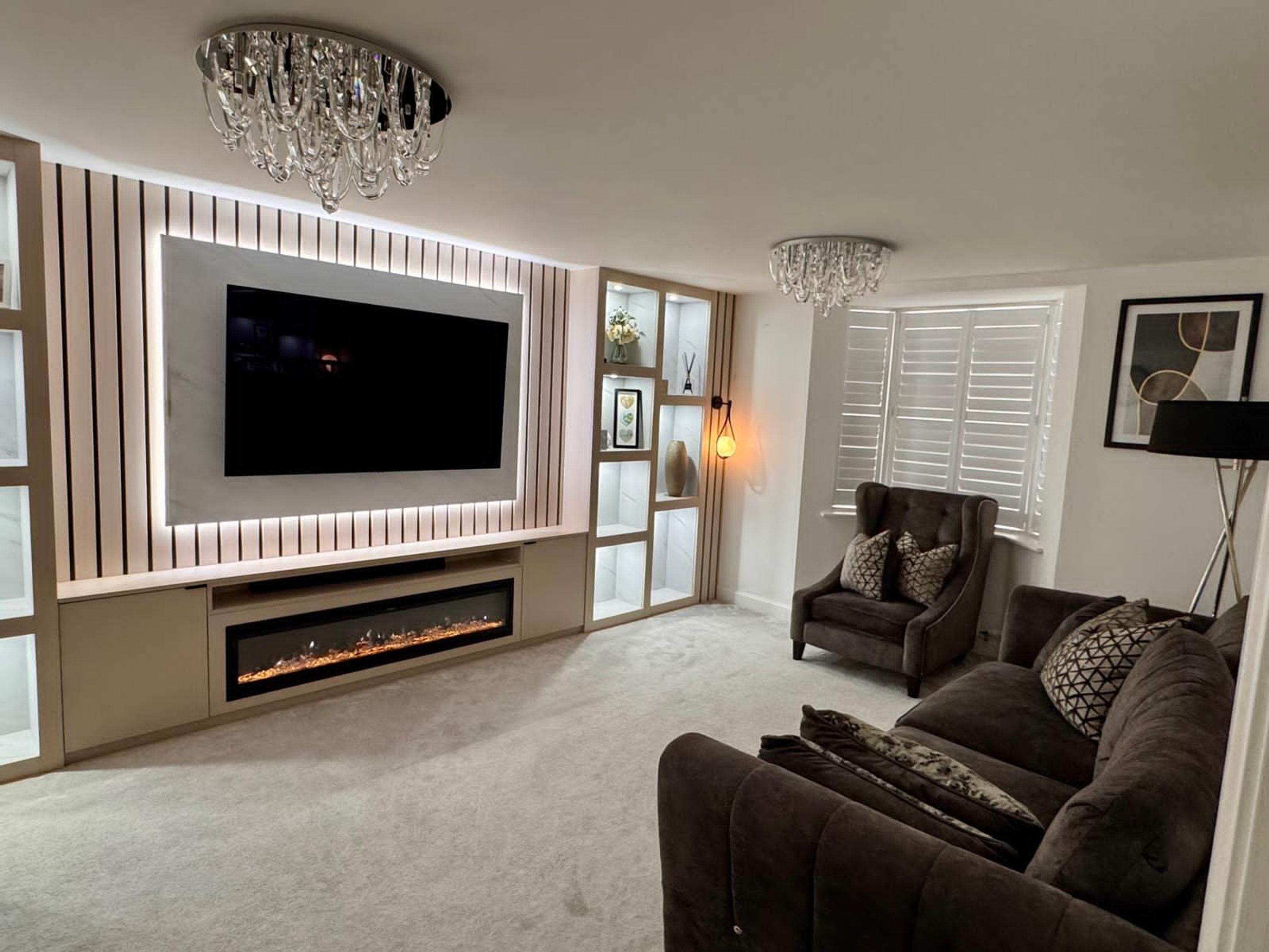 Ein modernes Wohnzimmer mit einem großen Flachbildfernseher an einer Wand aus Holzpaneelen, einem Kamin darunter und einem gemütlichen Sofa mit Kissen.