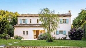 A two-story house with a stone foundation, a tiled roof, and a well-maintained lawn. - CASA-Noel villa avec piscine privée (Saint-Paul-de-Vence)