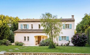 A two-story house with a stone foundation, a tiled roof, and a well-maintained lawn. - CASA-Noel villa avec piscine privée (Saint-Paul-de-Vence)