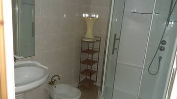 Een douche, handdoeken, zeep, toiletpapier