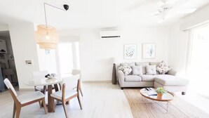 Un salon moderne comprenant un coin repas, un ensemble de canapés et une table basse.