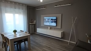 A modern living room with a dining area, a flat-screen TV mounted on the wall, and a minimalist design. - Work & relax home paderno dugnano rho fiera (Paderno Dugnano)