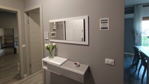 A modern bathroom with a large mirror, a small vanity, and a vase with flowers. - Work & relax home paderno dugnano rho fiera (Paderno Dugnano)