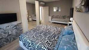A modern bedroom with a large bed, a sofa, a TV, and a mirror. - Work & relax home paderno dugnano rho fiera (Paderno Dugnano)