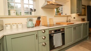 A kitchen with a stove, oven, sink, and cabinets. - Bridge House Cottage (Harrogate)