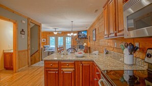 A spacious kitchen with wooden cabinets, granite countertops, and a central island. - Loggers Run #7: 5 Bedrooms, 3.5 Bath: Slope Side. Overlooks The Ski Trail ! (Snowshoe)