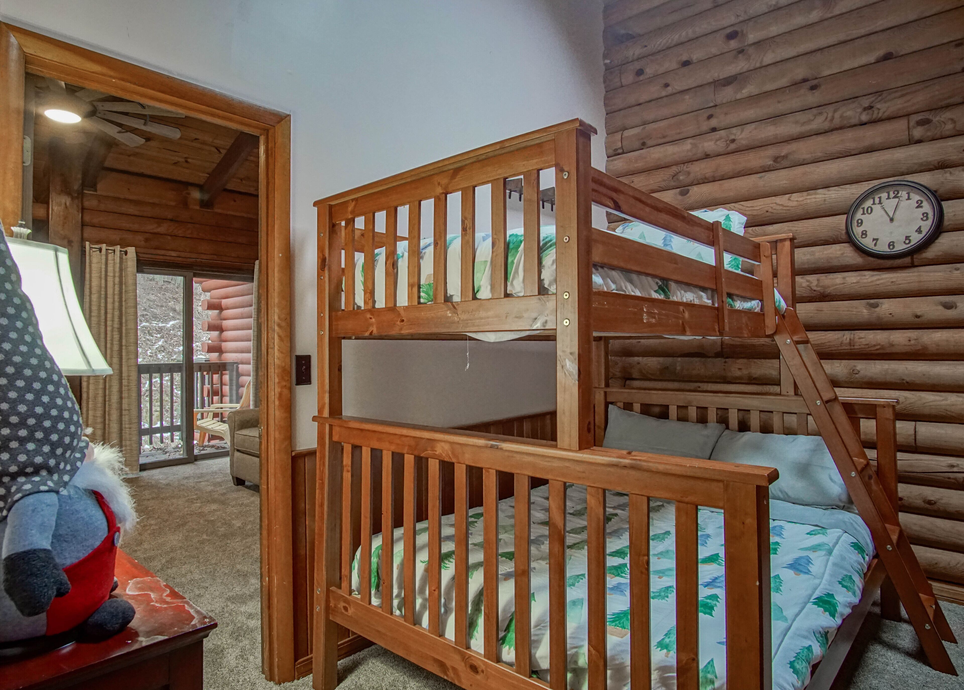 A bunk bed with a wooden ladder, a clock on the wall, and a view of the outside through a window.