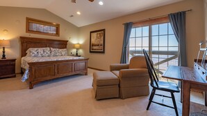 A bedroom with a bed, a chair, a desk, a ceiling fan, a window with curtains, and a framed picture on the wall. - Top Property In Snowshoe 8 Br Nwr Rd 11 Luxury Home (Snowshoe)