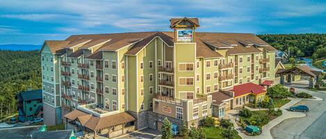 A multi-story hotel with a central courtyard, balconies, and a ski lift on the roof.