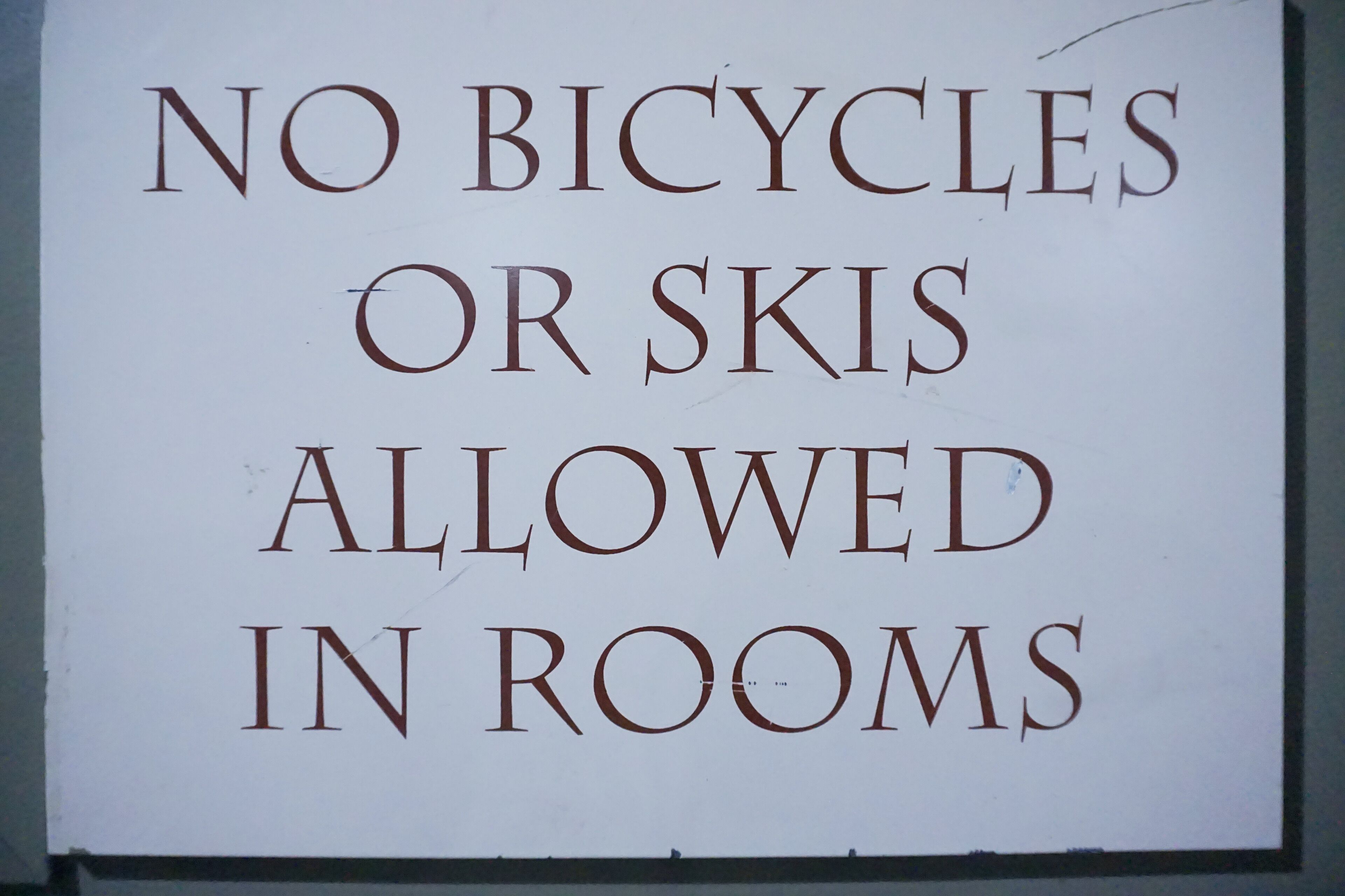 A sign with the text "NO BICYCLES OR SKIS ALLOWED IN ROOMS".