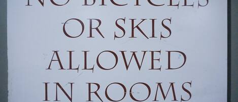 A sign with the text "NO BICYCLES OR SKIS ALLOWED IN ROOMS".