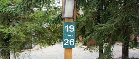 A wooden post with a green sign displaying the numbers 19 and 26.