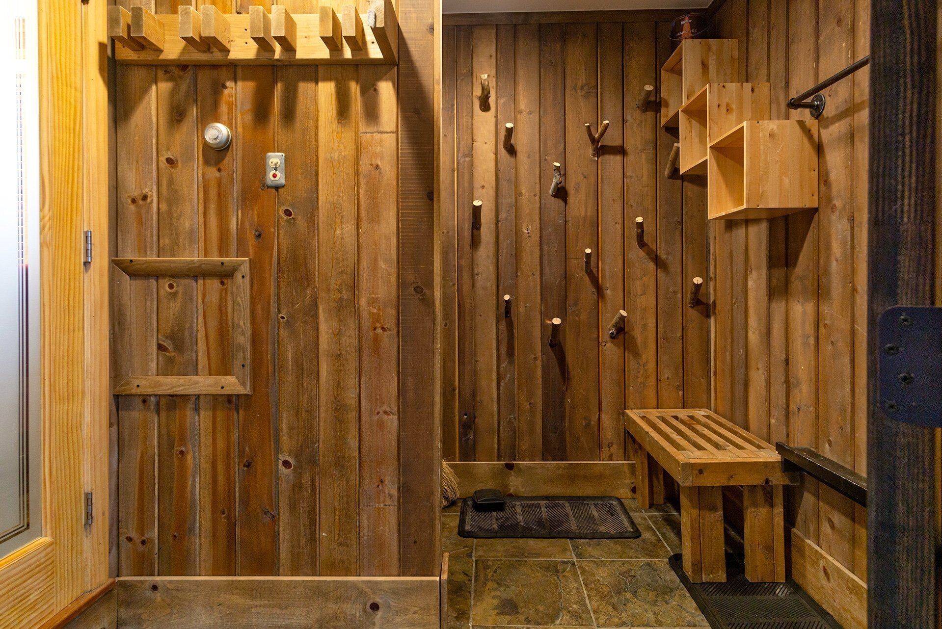A wooden sauna room with benches, a bench with a towel, and a bench with a towel.