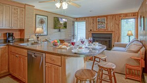 A spacious kitchen with wooden cabinets, a central island with seating, a dishwasher, and a ceiling fan. - Powderidge 1 Hideaway Slope Side (Snowshoe)
