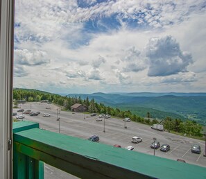 Um estacionamento com vários carros e um edifício ao fundo.