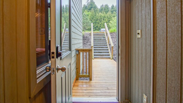 A wooden deck leading to a staircase with a view of a forested area. - Powderidge 60: Slope Side, Fireplace, Spacious Deck (Snowshoe)