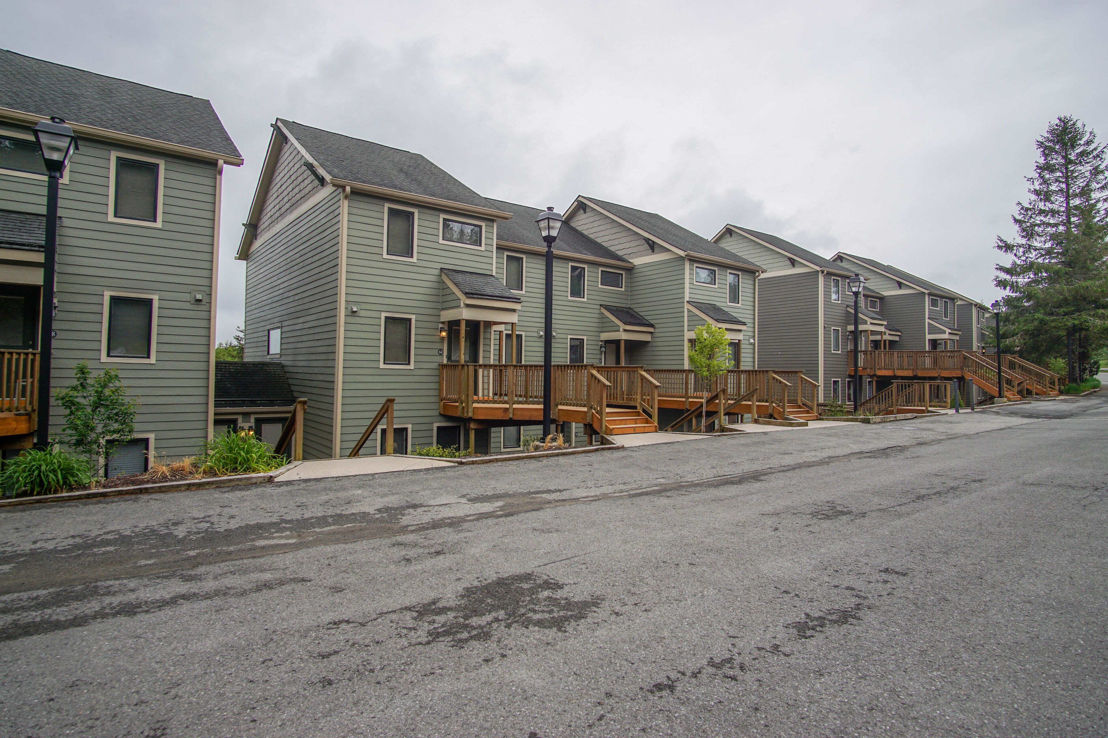 A row of townhouses with wooden decks and staircases leading to the entrance.