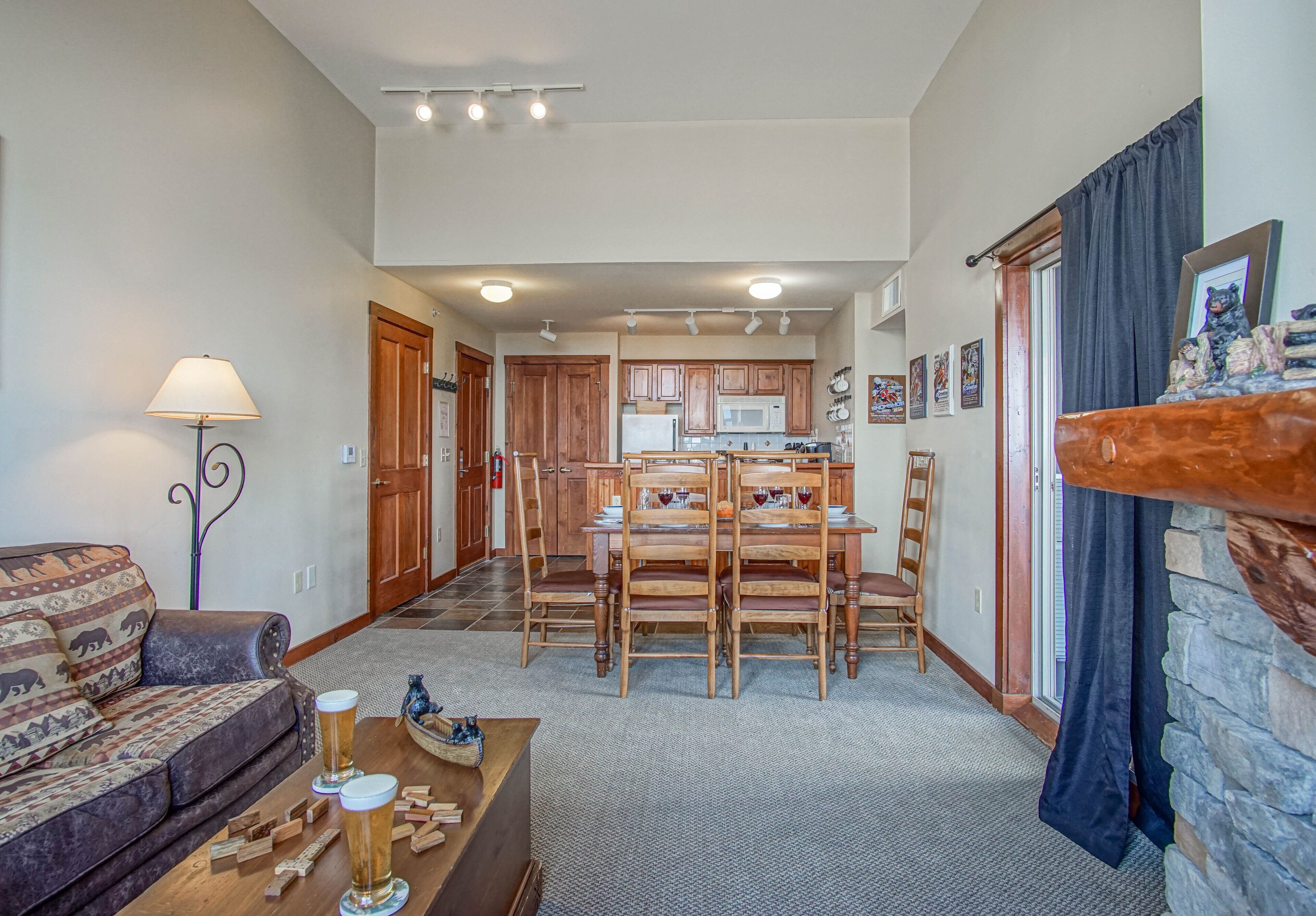 A spacious living room with a sofa, coffee table, and a dining area with wooden chairs and a table.