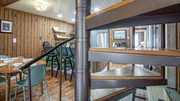 A wooden interior with a staircase, dining area, and kitchen. - 2 Br: Wabasso 5: 2br, 2 Bath (Snowshoe)