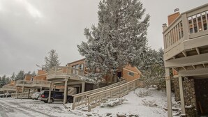 A residential area with snow-covered trees and a building with a balcony. - 2 Br: Wabasso 5: 2br, 2 Bath (Snowshoe)