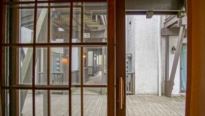 A wooden deck with a view of a building's interior through a glass door. - Whistlepunk #31: 2 Bedrooms, 2 Bath: Slope Side, Central Location. Wood Fireplace (Snowshoe)