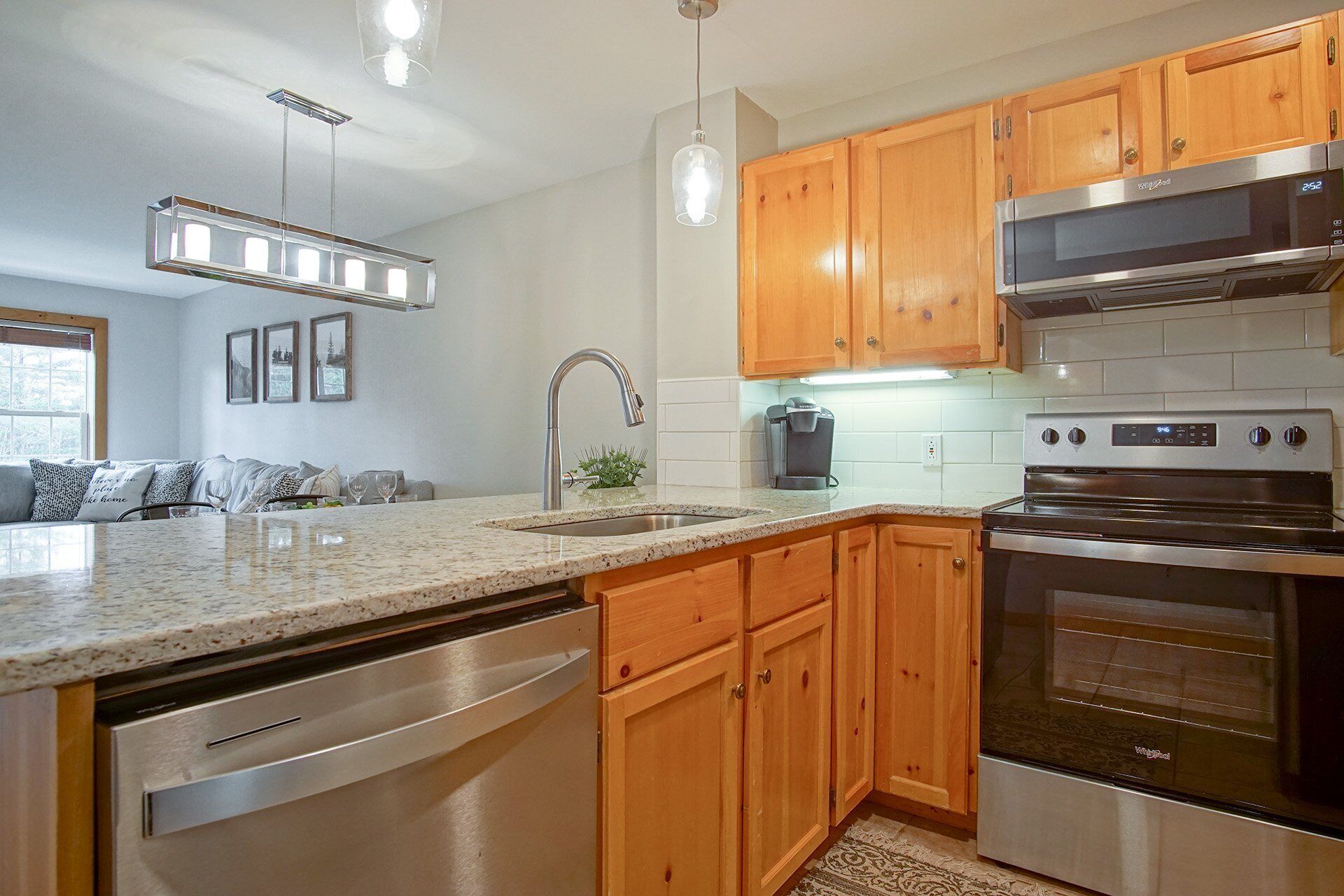Una cocina moderna con armarios de madera, electrodomésticos de acero inoxidable y encimera de granito.
