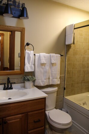 A bathroom with a sink, mirror, toilet, and bathtub. - Whistlepunk 45- Modern Comfort With Mountain Charm-1 Bedroom (Snowshoe)