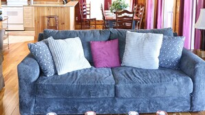 A cozy cabin interior with a wooden ceiling fan, a dining area, and a living room with a blue sofa. - 4 BR: Timbers #1 Stand Alone Cabin (Snowshoe)