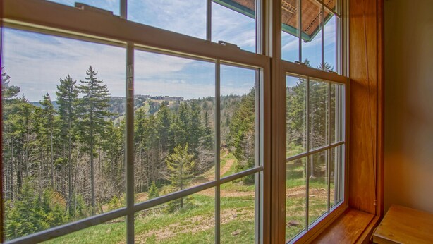 A room with a large window offering a view of a forested landscape. - Camp 4 #21: 2 Bedrooms, 2.5 Baths: Slope Side, Gas Fireplace (Snowshoe)