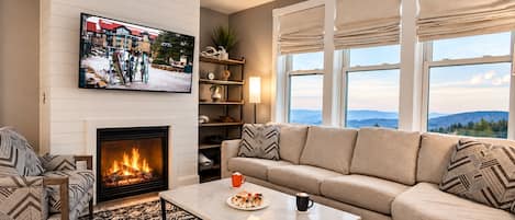A living room with a fireplace, a sofa, a coffee table, and a television.